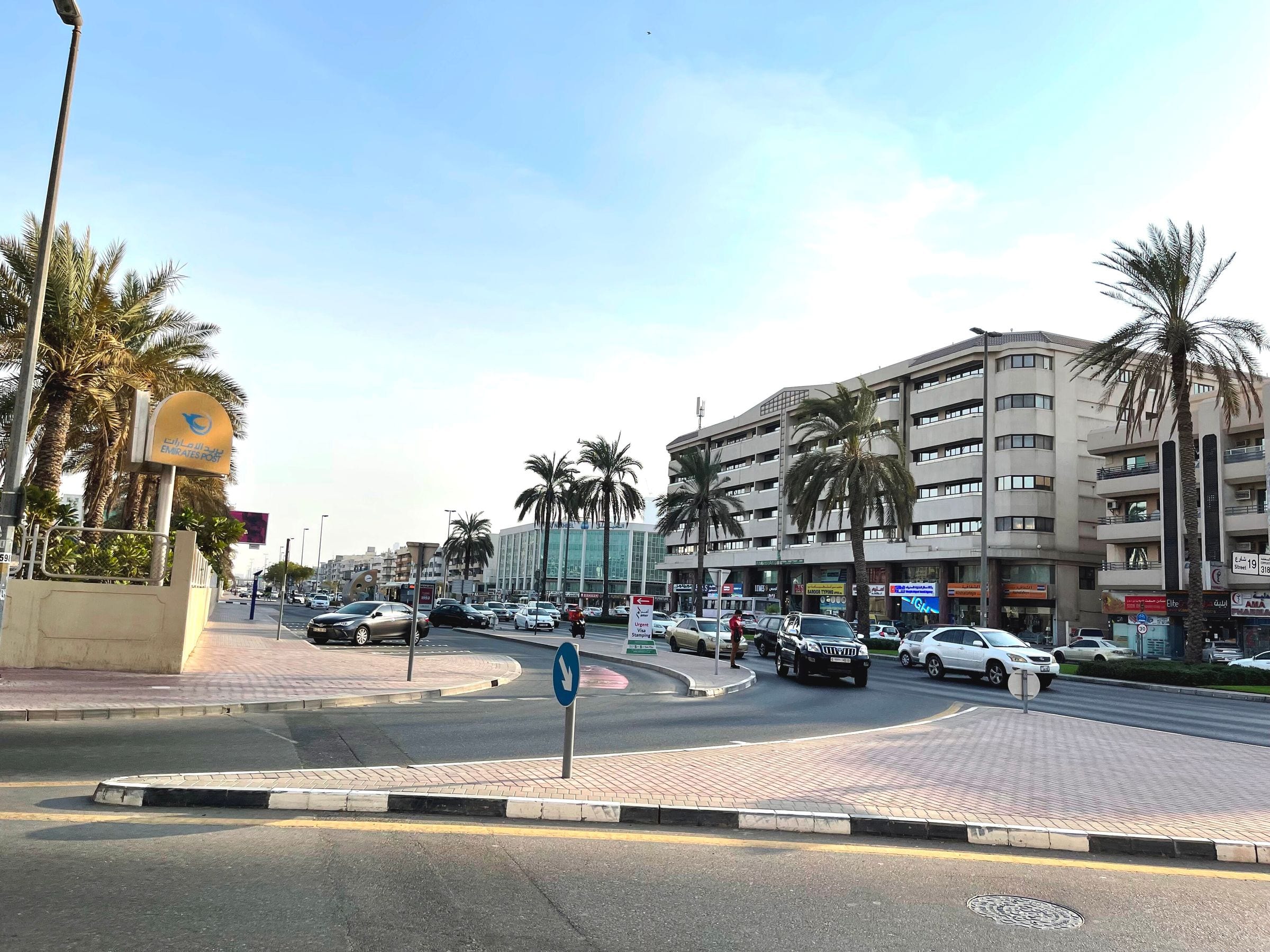 Low-rise apartment blocks and palm trees on a Karama street